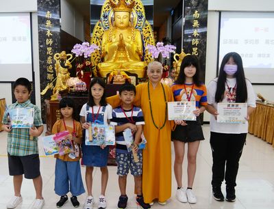 08-1董事長賢度法師與小朋友、智光學生合影。