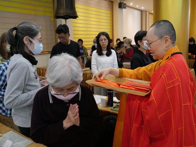 07美國華嚴蓮社副董事長天承法師分送福袋。
